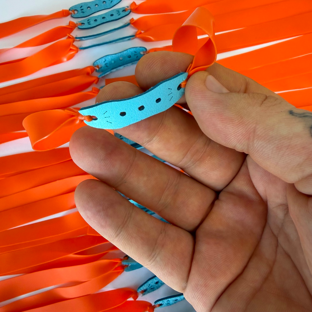 Detail view of 215mm orange flat band demonstrating consistent elasticity and controlled power for backyard practice | Armament Mfg.