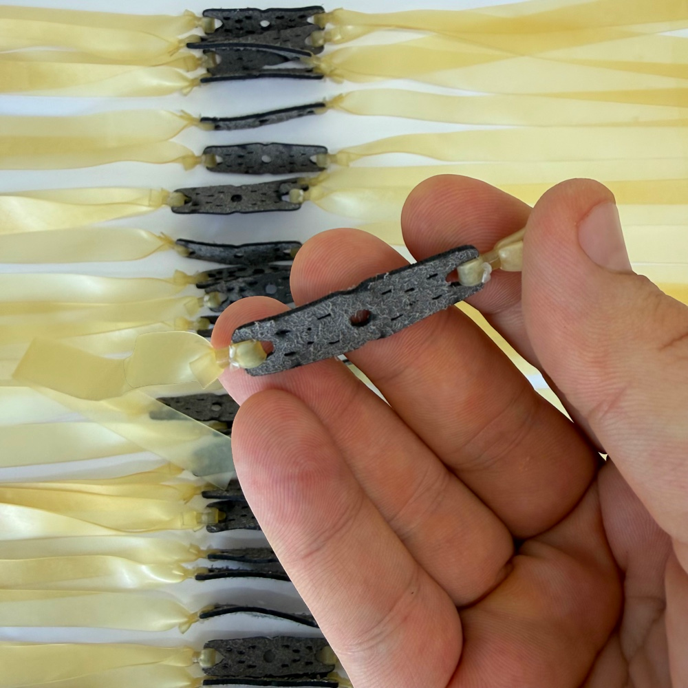Detail view of 215mm transparent latex flat band demonstrating pouch design for balanced power and control | Armament Mfg.