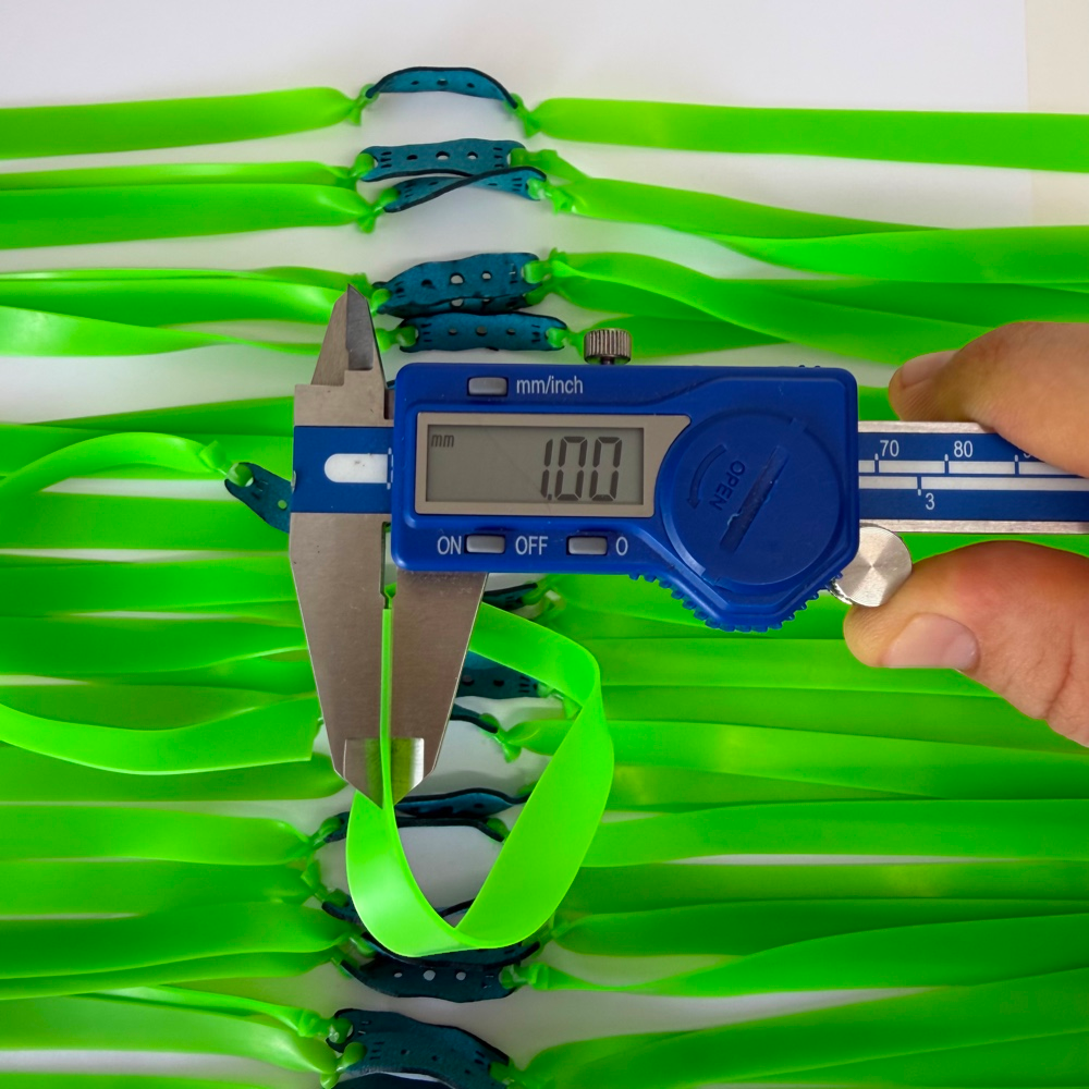 Close-up of premium natural latex band showing 1.0mm thickness and vibrant neon green color for high visibility | Armament Mfg.