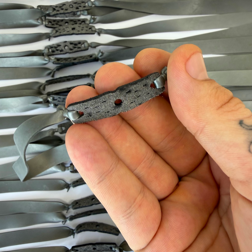 Detail view of 215mm silver flat band demonstrating excellent elasticity and powerful rebound for precision shooting | Armament Mfg.