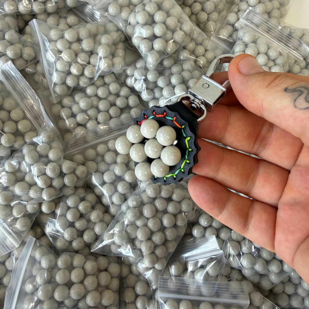 Detail view of 10.5mm biodegradable clay pellets demonstrating magnetic properties for easy retrieval | Armament Mfg.