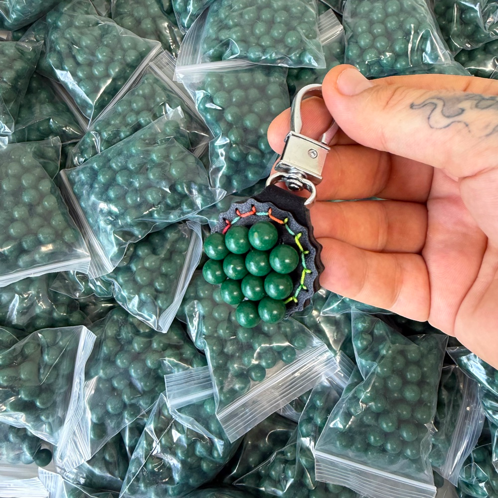 Detail view of 9.5mm biodegradable clay pellets demonstrating magnetic properties for easy retrieval | Armament Mfg.