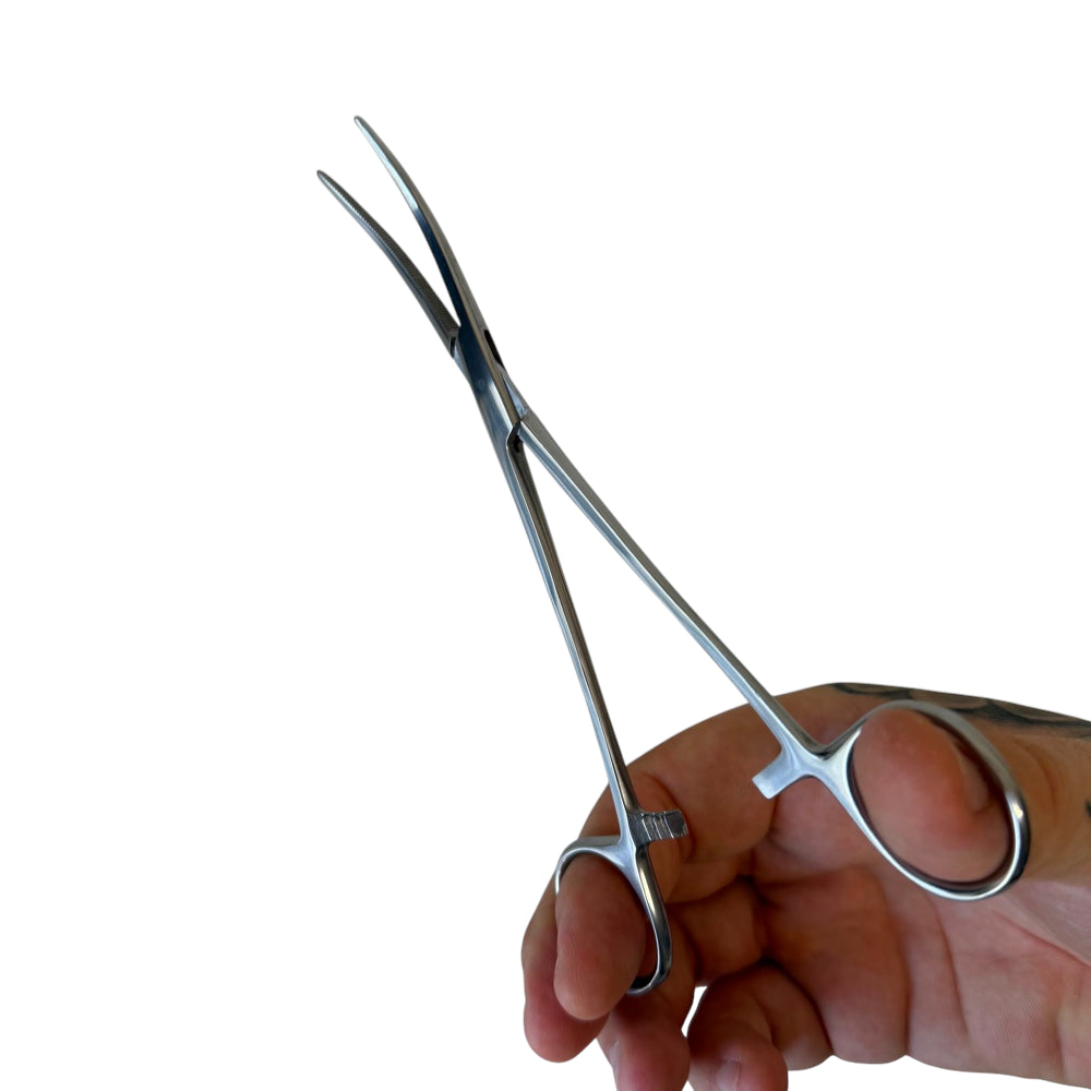Close-up of locking hemostat clamp showing curved tip design for tight space band assembly and precision work | Armament Mfg.